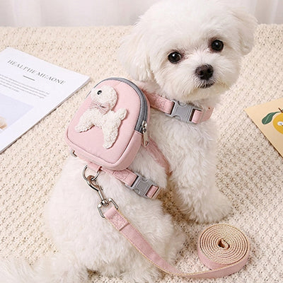 petit chien blanc portant harnais pour chien sac a dos rose avec laisse assortie
